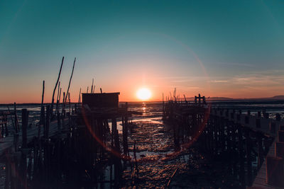 Pier over sea against sky during sunset