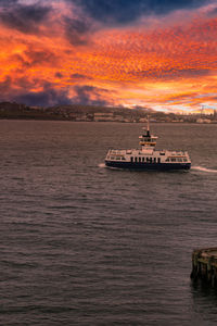 Ship sailing on sea against sky during sunset