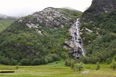 Scenic view of land and mountains against sky