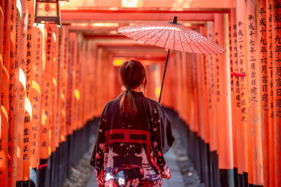 Rear view of woman walking in temple outside building