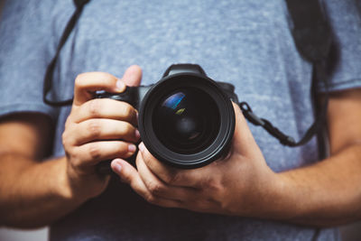 Midsection of man photographing camera