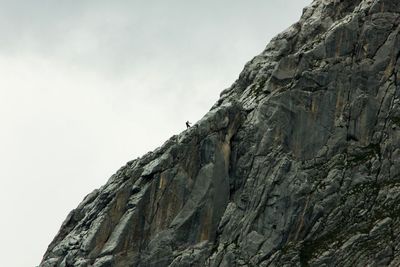 Low angle view of rocky mountain against sky