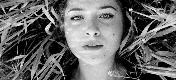 Close-up portrait of a young woman lying down