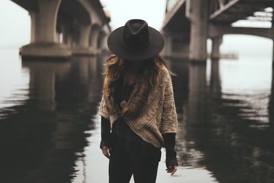 Rear view of woman standing in river