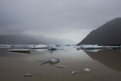 Scenic view of lake against sky during winter