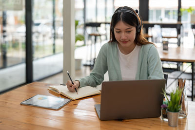 Young woman using laptop at table