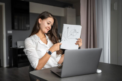 Young woman using laptop while sitting at home