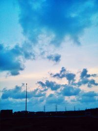 Low angle view of power lines against blue sky