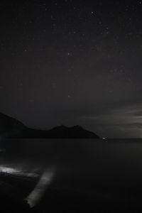 Scenic view of lake against sky at night