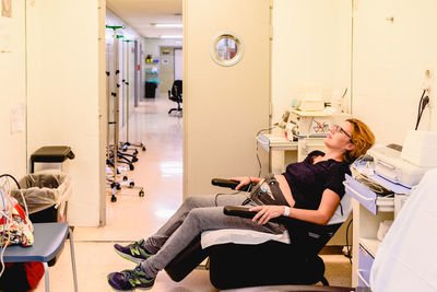 Full length of woman sitting on chair