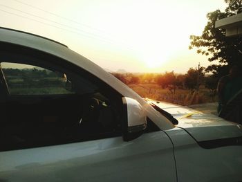 Close-up of car against sky during sunset