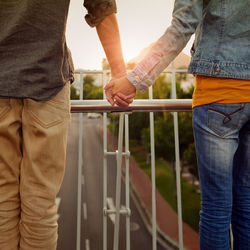 Midsection of couple holding hands