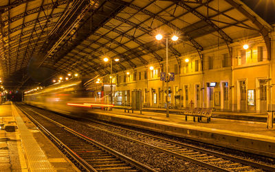 Train at railroad station platform at night