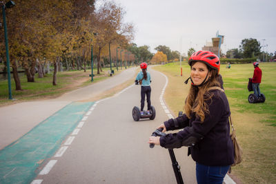 Portrait of smiling woman riding hoverboard on road