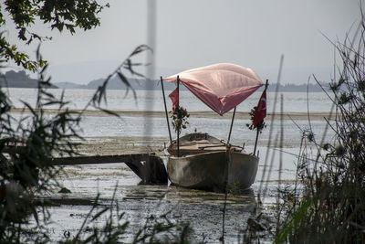 Boat moored in lake against sky