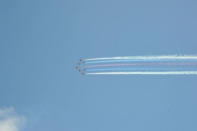 Low angle view of airshow against clear blue sky