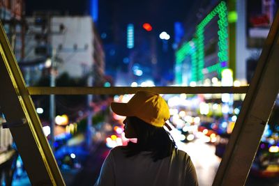 Rear view of woman in city at night