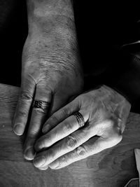 Cropped hands of couple showing rings on table