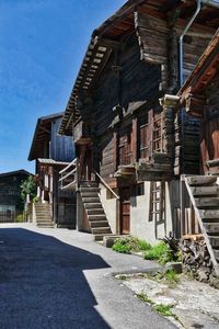 Exterior of houses by building against sky