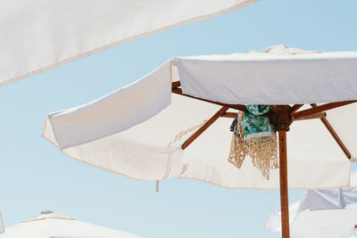 Low angle view of parasol against blue sky