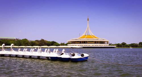 Ship moored in sea against clear blue sky