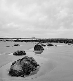 Panoramic view of rocks on beach against sky