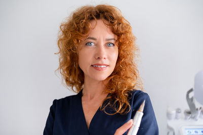 Portrait of young woman against white background