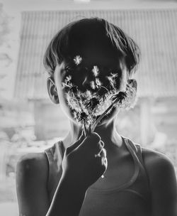 Close-up portrait of a boy blowing dandelion seeds