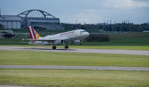 Airplane on airport runway against sky