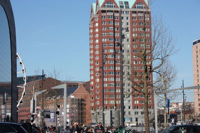 Cars on street by buildings against sky in city