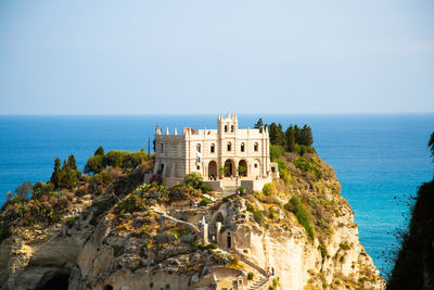 Building by sea against clear sky