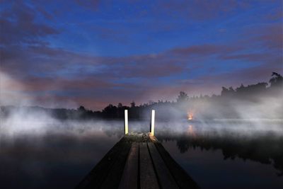 Pier over lake against sky during sunset