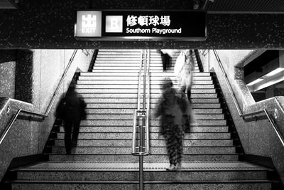 Blurred motion of people walking on steps at subway station