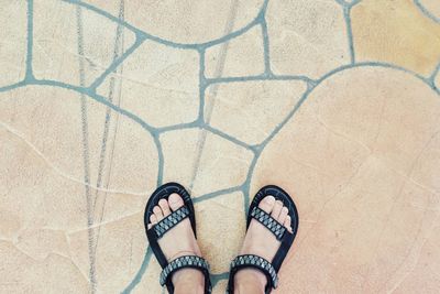 Low section of person standing on tiled floor