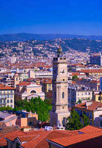 Aerial view of townscape against blue sky