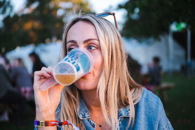 Portrait of young woman drinking beer