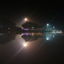 Illuminated lake against sky at night