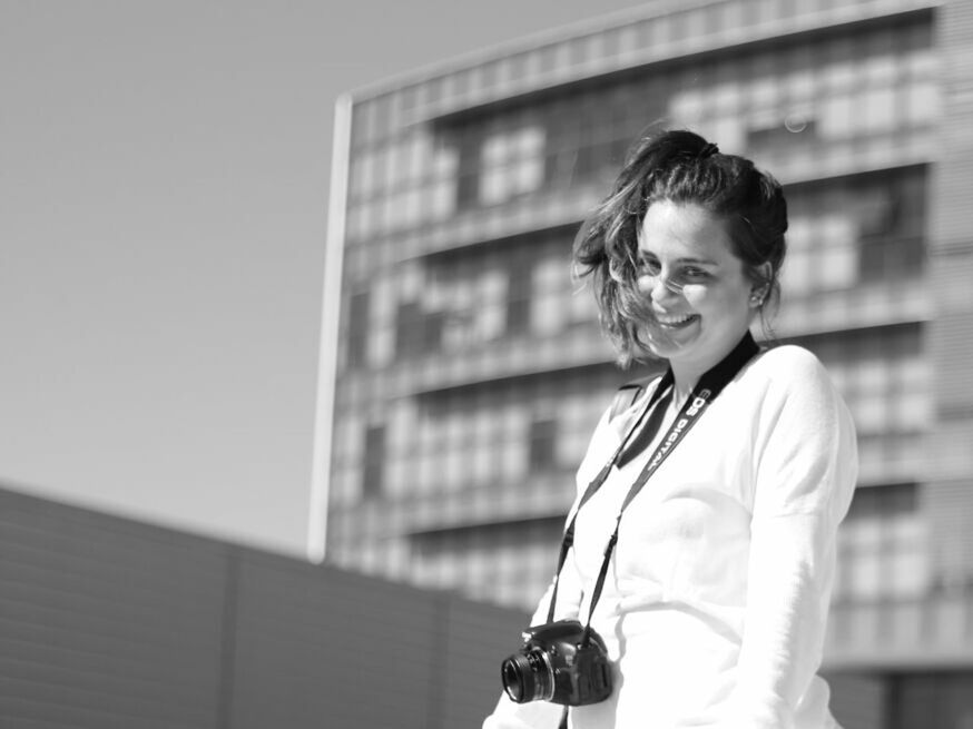 building exterior, architecture, built structure, person, young adult, lifestyles, casual clothing, leisure activity, waist up, focus on foreground, front view, young women, standing, side view, city, three quarter length, portrait, looking at camera