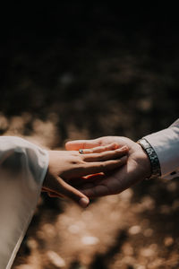 Midsection of couple holding hands in suny day