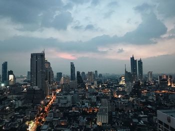 Illuminated buildings in city against sky