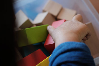 Cropped image of kid playing with toy blocks at home