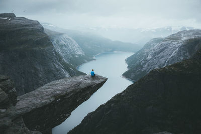 Men sitting on rock formation over river