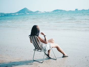 Woman sitting on chair at beach