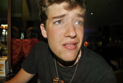 Portrait of young man looking at restaurant