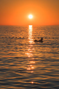 View of sea and man at sunset