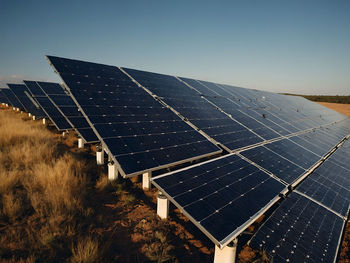 Solar panels on field against clear sky