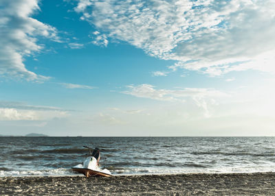 Woman looking at sea against sky