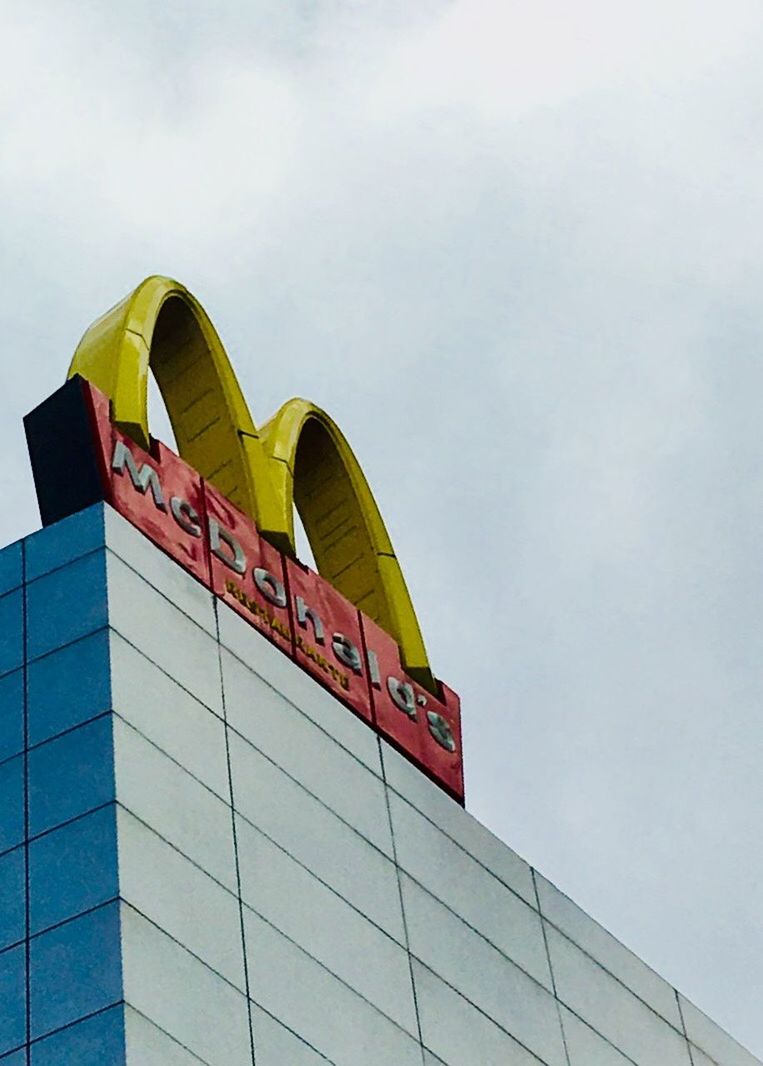 LOW ANGLE VIEW OF MULTI COLORED BUILDING AGAINST SKY