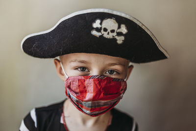 Portrait of school age young boy dressed as pirate with face mask on