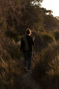 Full length rear view of women walking on field